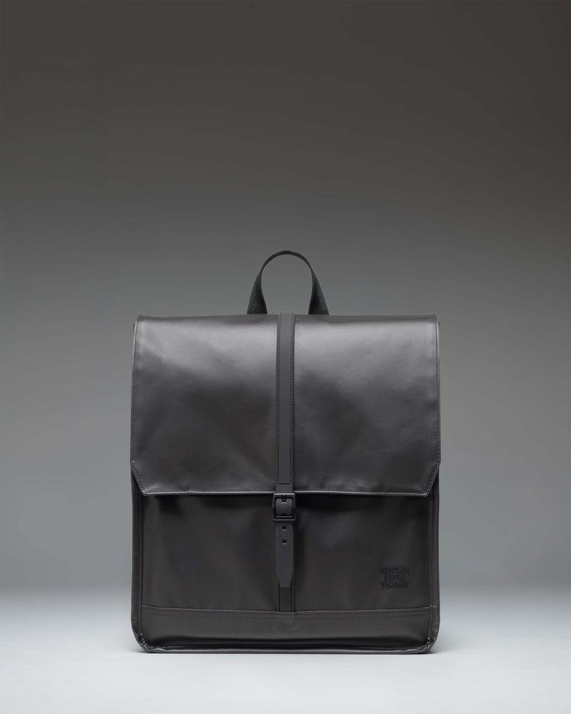 Herschel Supply Co City Backpack in black, showcasing a minimalist design with a single strap closure and a clean, modern aesthetic.