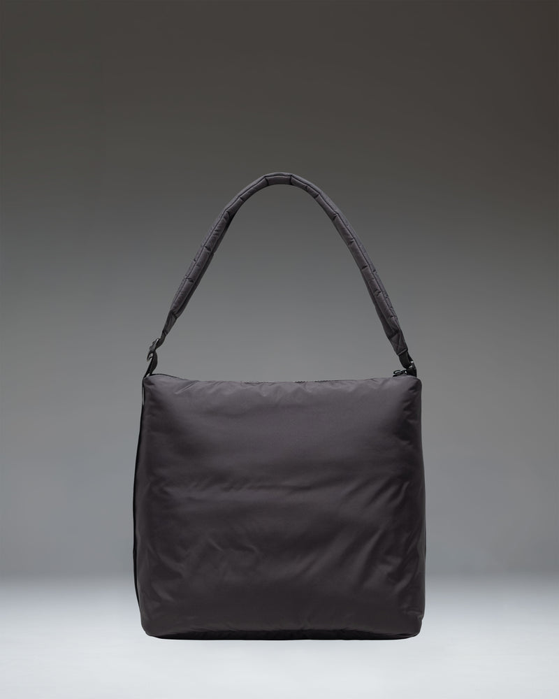 Herschel Supply Co. Cloudform Tote in black, showcasing its minimalist design, padded lightweight fabric, zippered closure, and adjustable strap.
