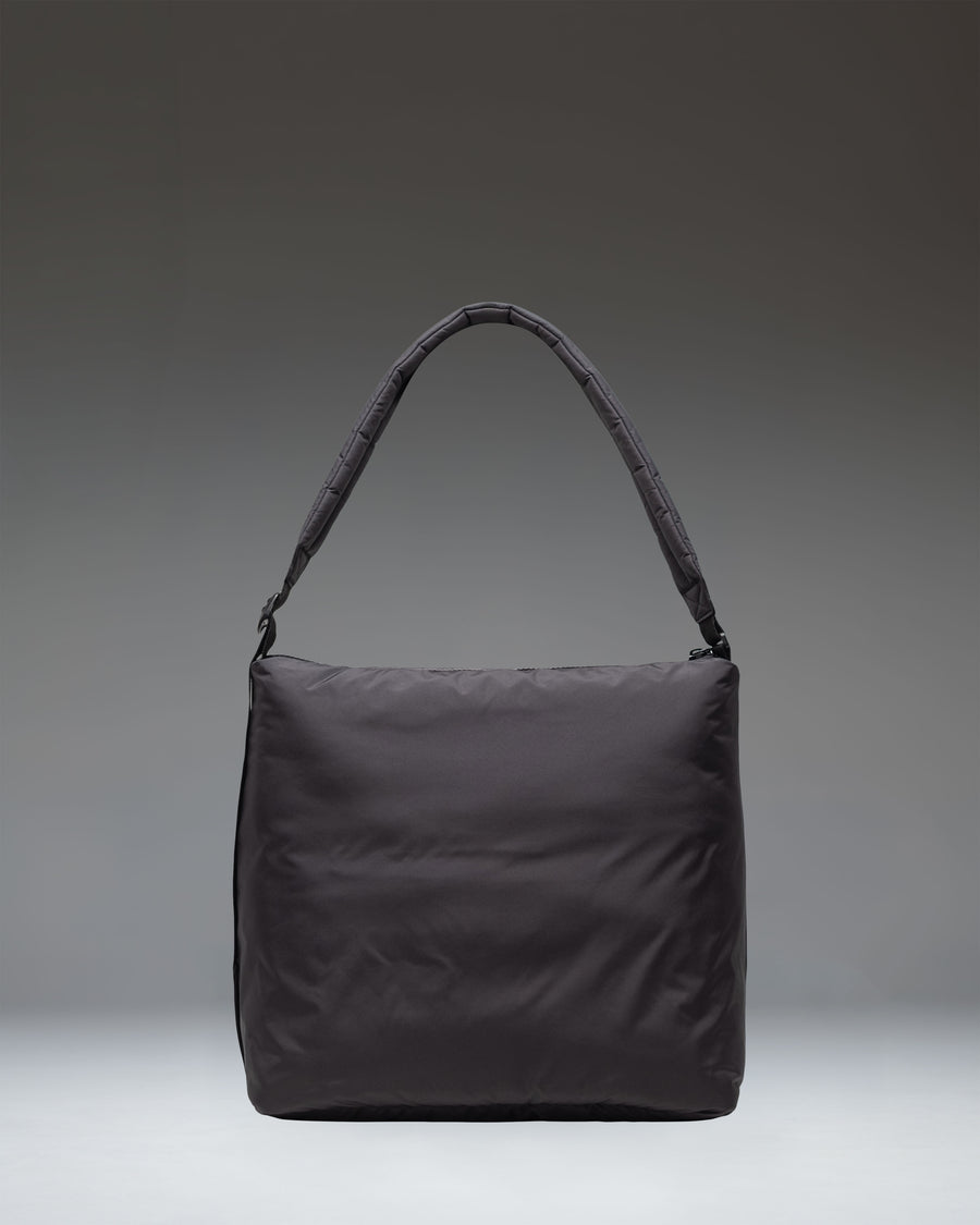 Herschel Supply Co. Cloudform Tote in black, showcasing its minimalist design, padded lightweight fabric, zippered closure, and adjustable strap.