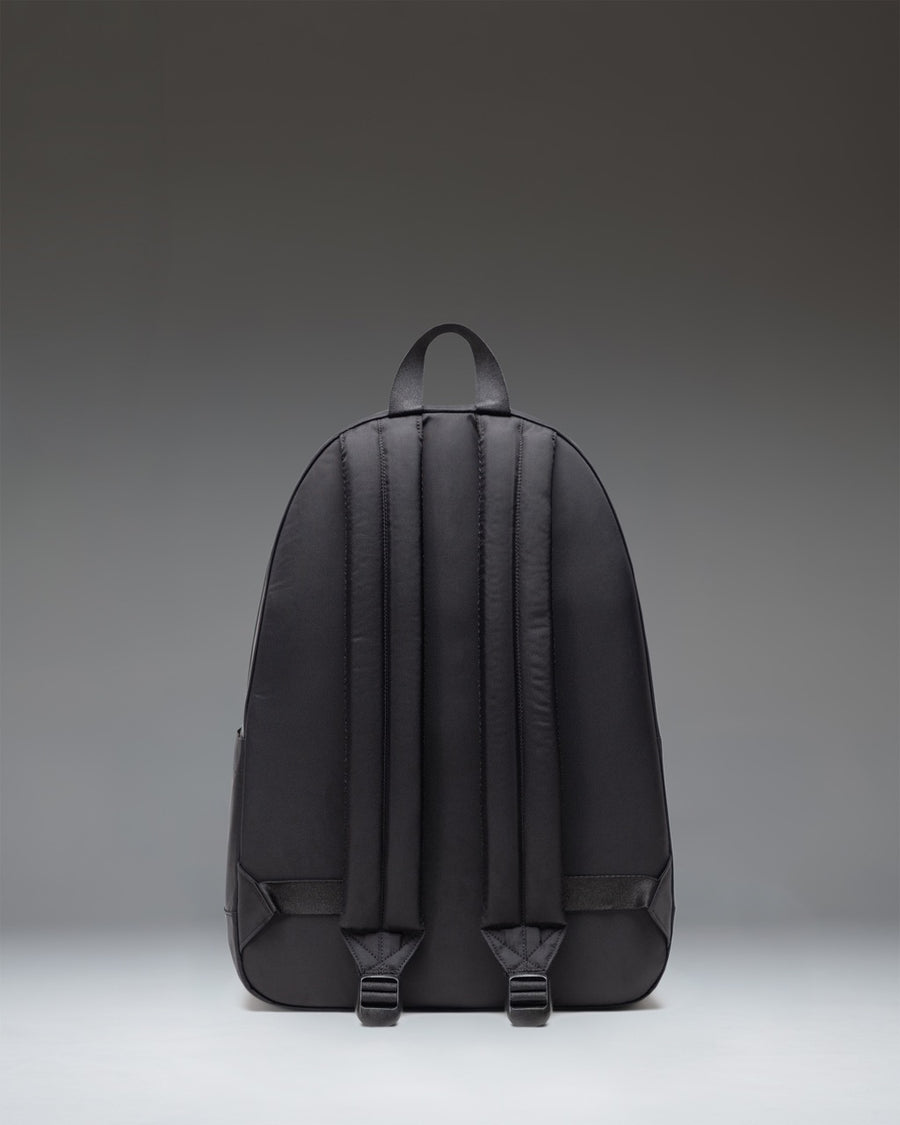 Black Herschel Classic XL Backpack in black, showcasing its clean, minimalist design with a front storage pocket and woven label.