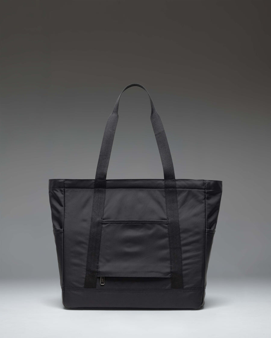 Black Herschel Supply Co. Heritage Tote bag featuring a zippered closure, top handles, front zip pocket, and signature diamond detail.