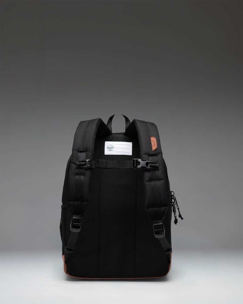 Herschel Heritage Kids Backpack in Black with Saddle Brown rubber strap detailing and a classic woven label.