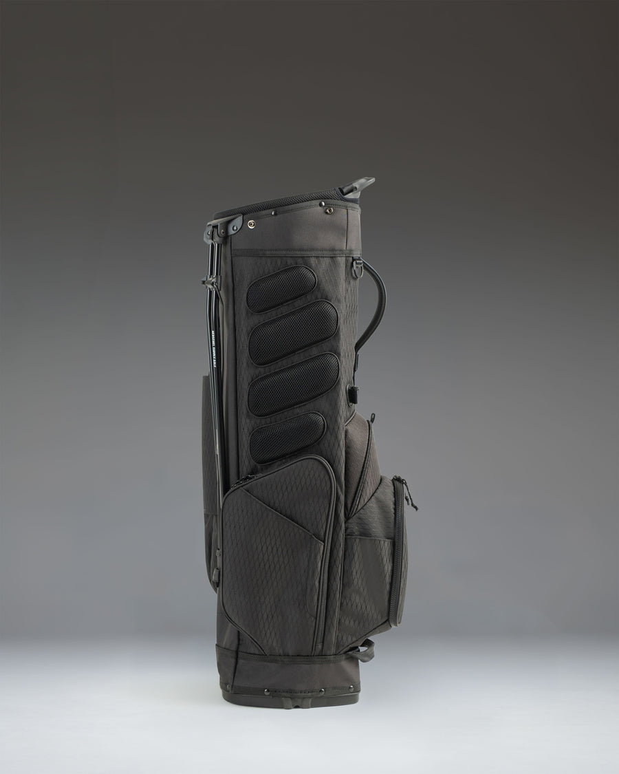 Black Herschel Watt Stand Bag showing an over-the-shoulder view of the dual carry straps and padded hip pad.