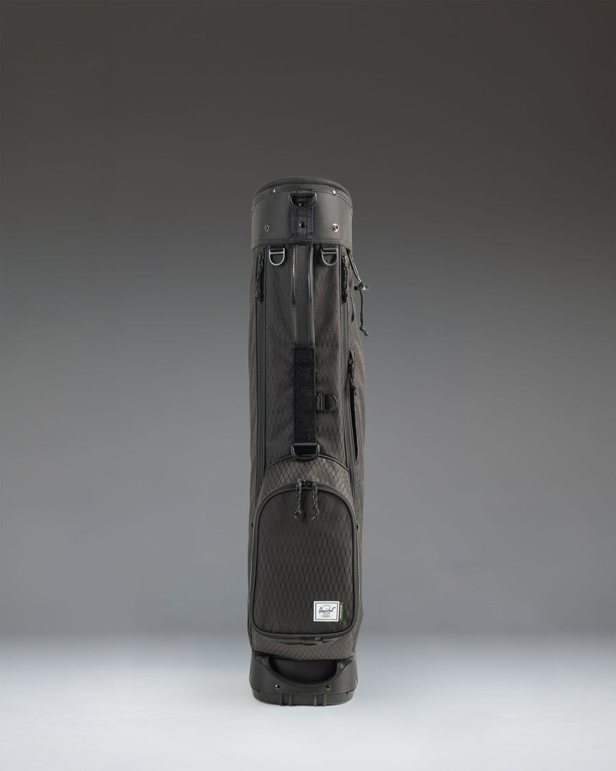 Black Herschel Watt Sunday Bag golf bag showing a side profile view with a carry strap and stand mechanism.