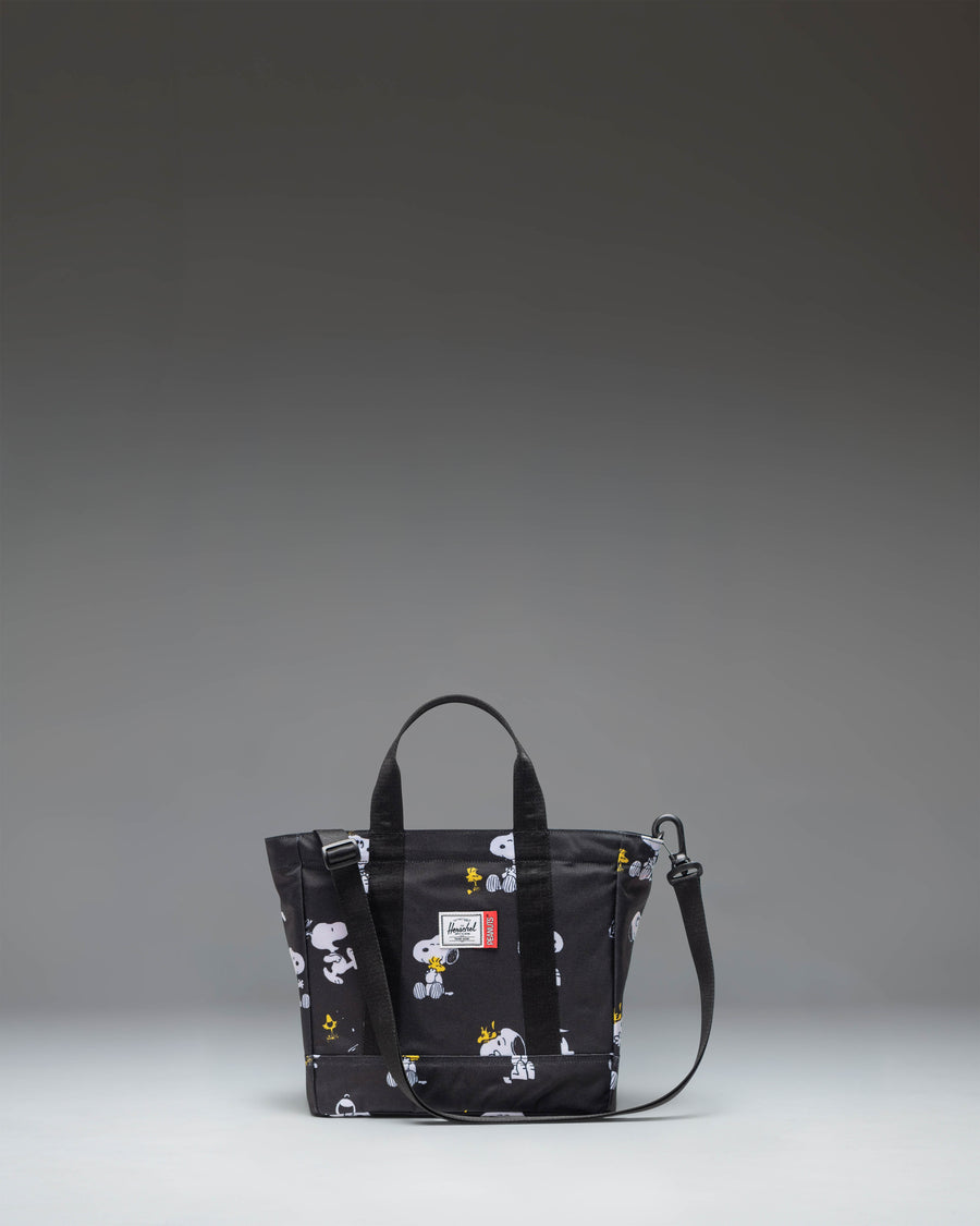 Black Peanuts Herschel Heritage Small Tote bag featuring a Snoopy and Woodstock graphic print on the front pocket.