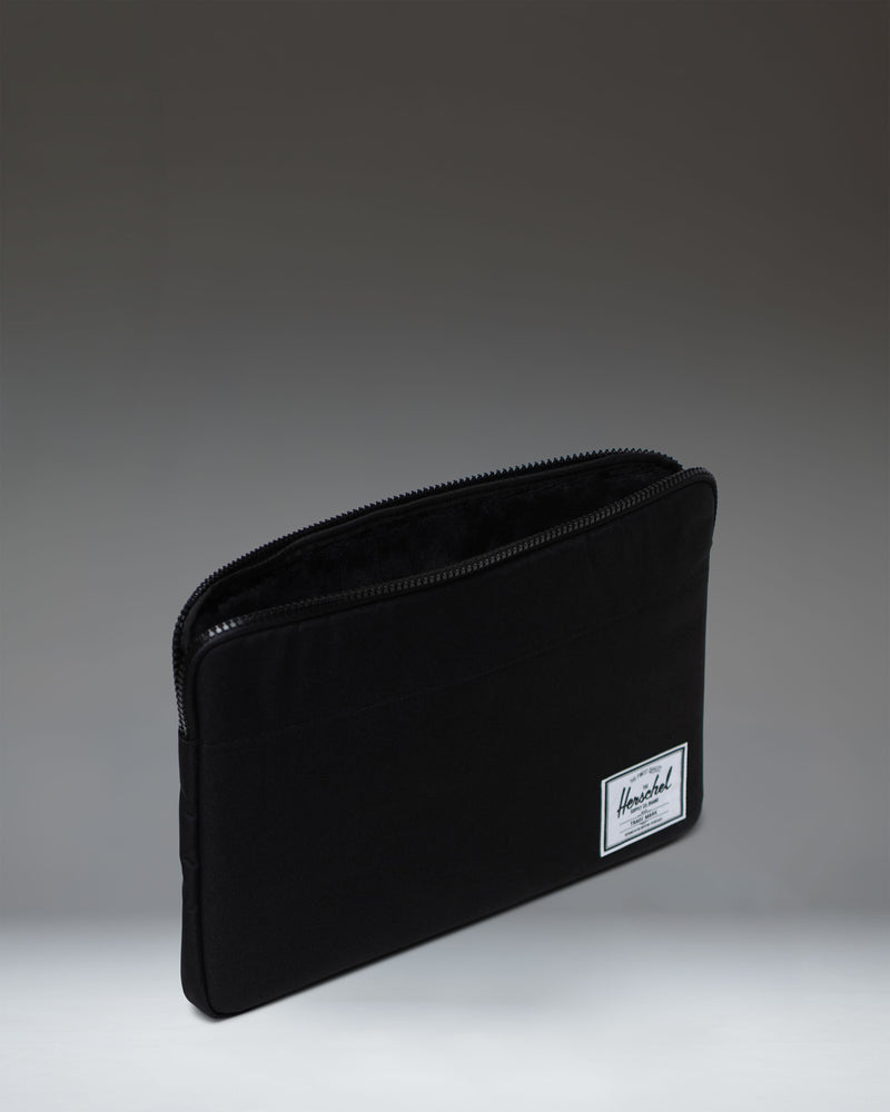 Herschel Supply Co. Anchor 15-16 Inch Sleeve in Black, showing a close-up lifestyle view of the durable tech sleeve.