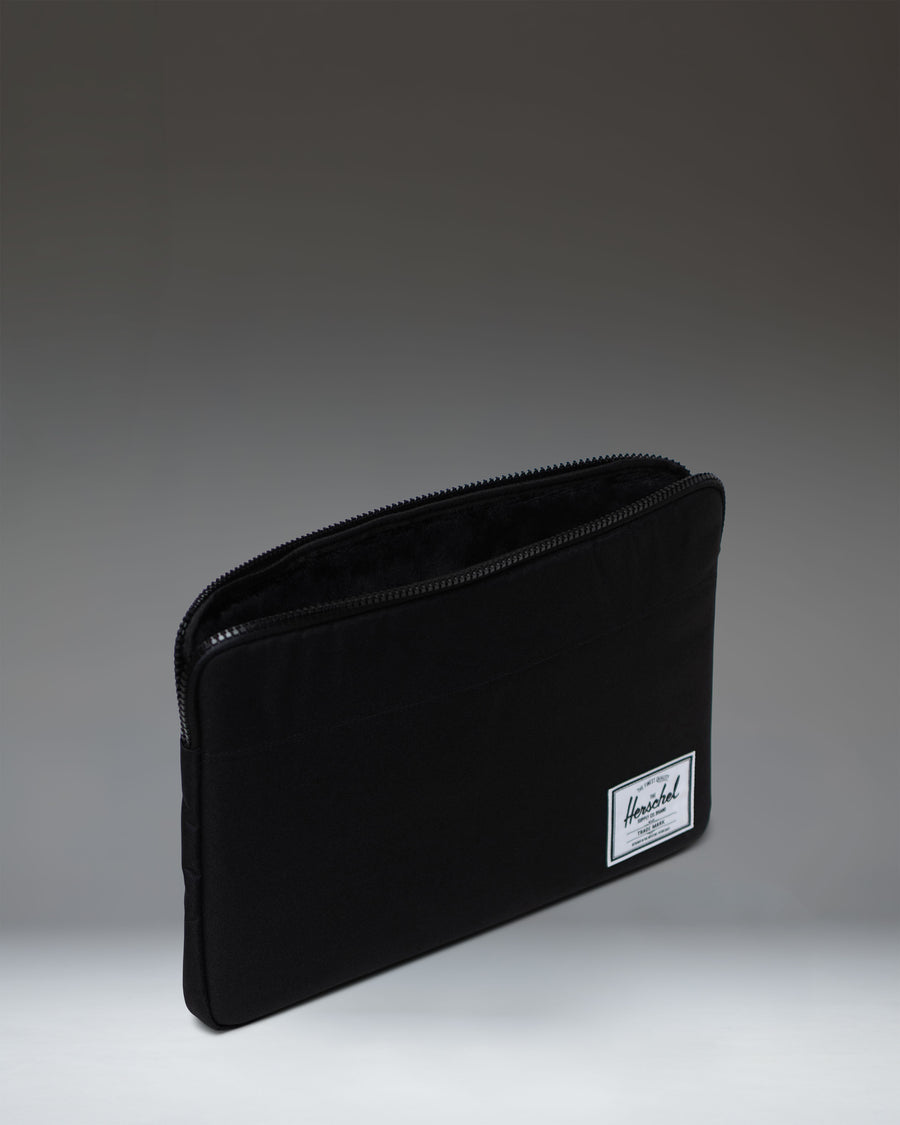 Herschel Supply Co. Anchor 15-16 Inch Sleeve in Black, showing a close-up lifestyle view of the durable tech sleeve.
