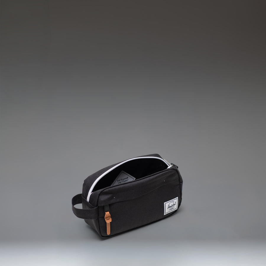 Herschel Supply Co. Chapter Small Travel Kit in Black, showing the side profile with its convenient carrying handle.
