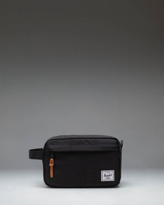 Herschel Supply Co. Chapter Travel Kit in black, showing the clean exterior design, side handle, and front zippered pocket.