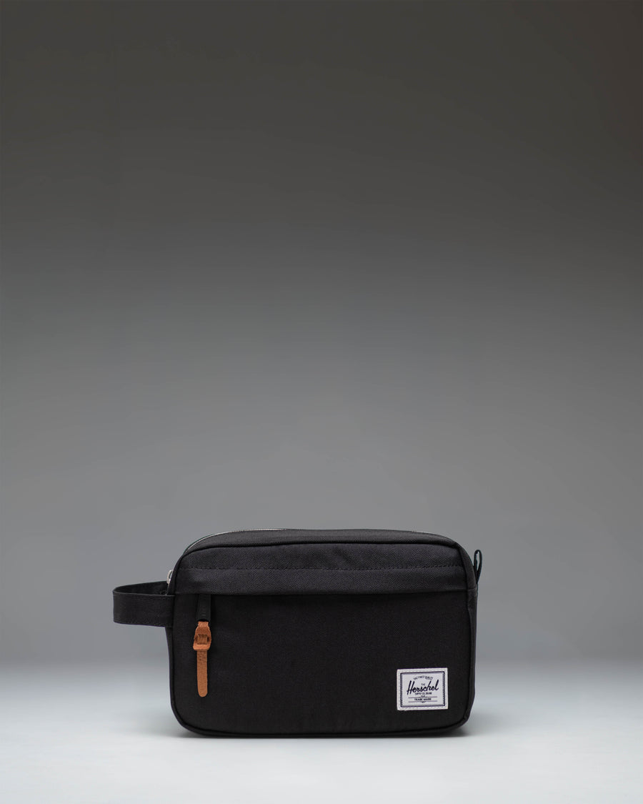 Herschel Supply Co. Chapter Travel Kit in black, showing the clean exterior design, side handle, and front zippered pocket.
