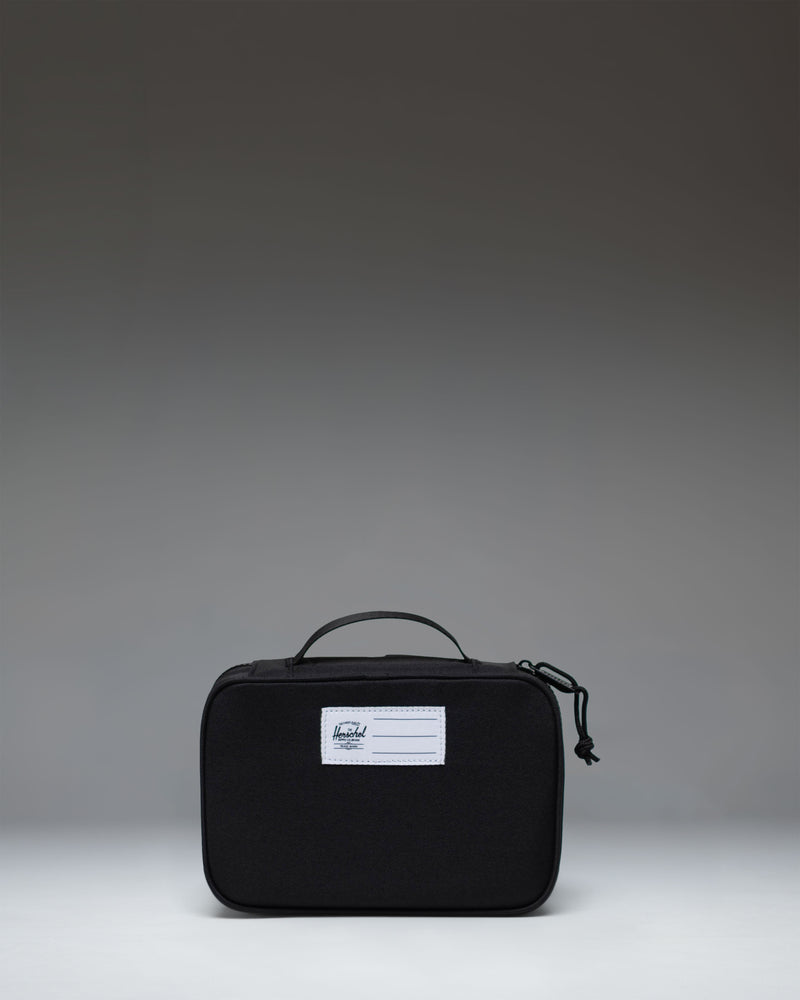 Herschel Supply Co Little Herschel Heritage Pencil Case in black, lifestyle view showing the front and carrying handle.