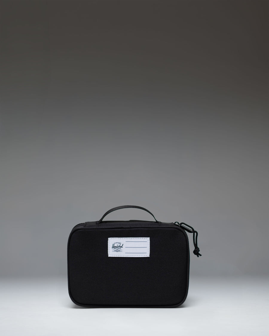 Herschel Supply Co Little Herschel Heritage Pencil Case in black, lifestyle view showing the front and carrying handle.