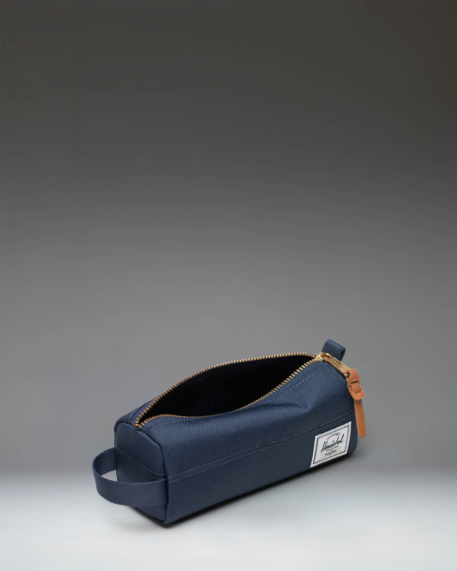 Herschel Supply Co. Settlement Pencil Case in Navy, showing a side view of the classic zippered pouch design.