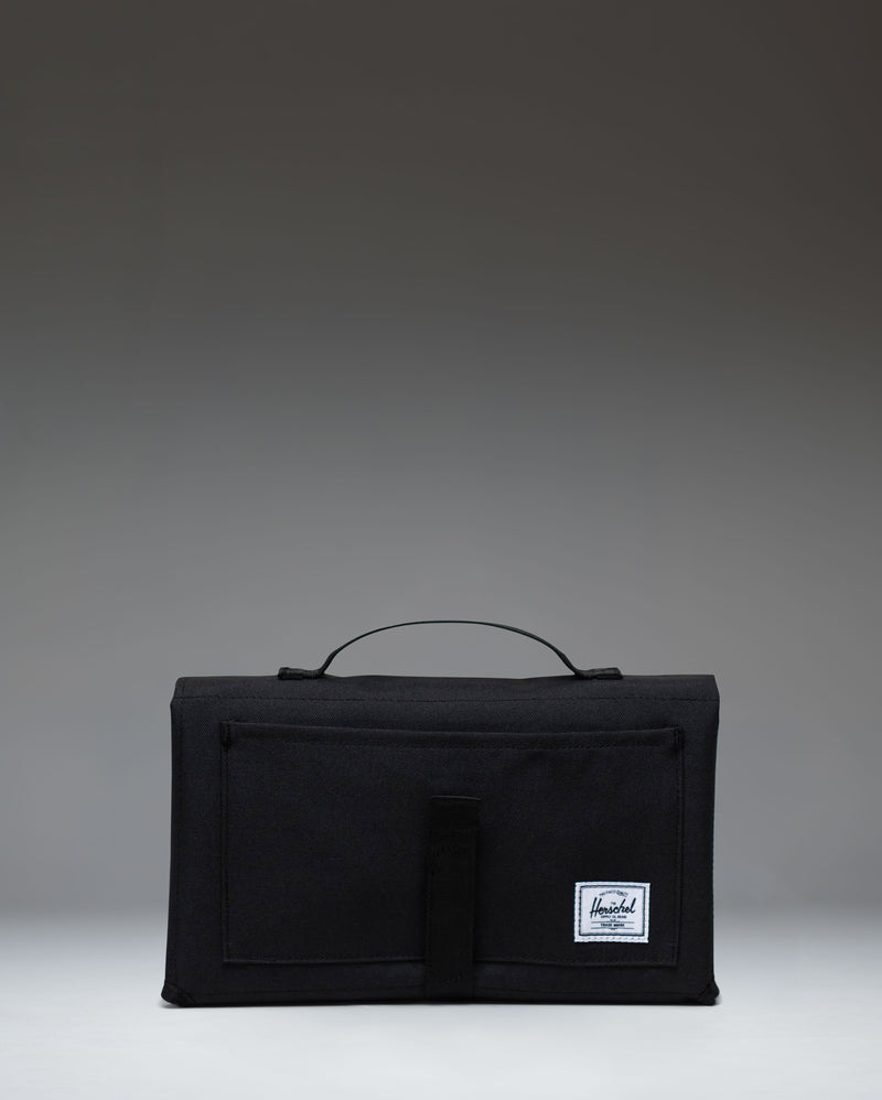 Black Herschel Supply Co. Sprout Change Mat, unfolded to show the padded mat surface and mesh storage pockets for baby essentials.
