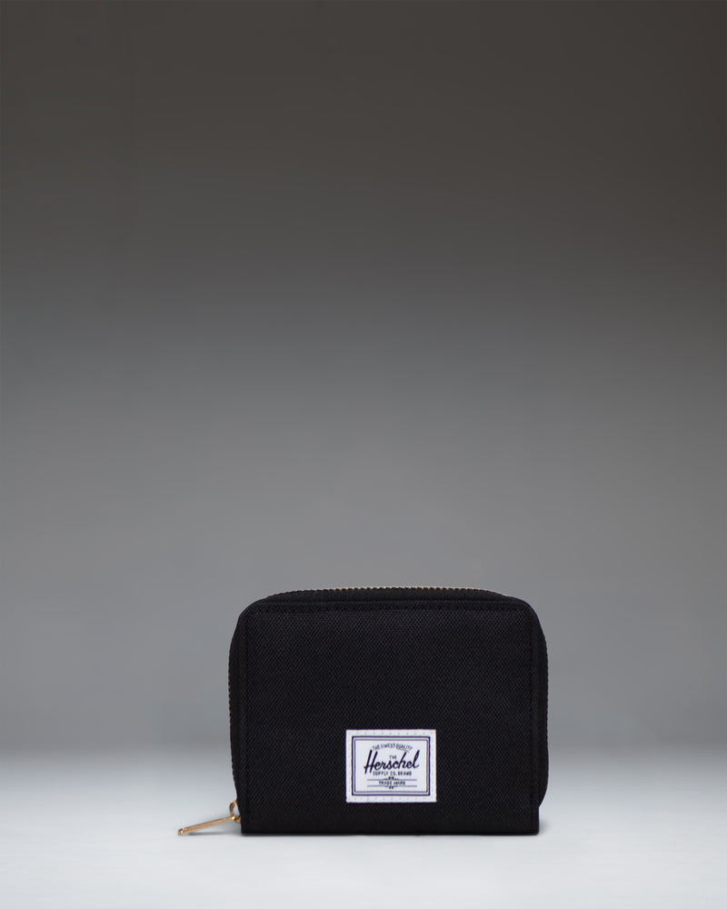Herschel Supply Co Tyler Wallet in black, displaying a classic zippered design with the signature woven label on the front.
