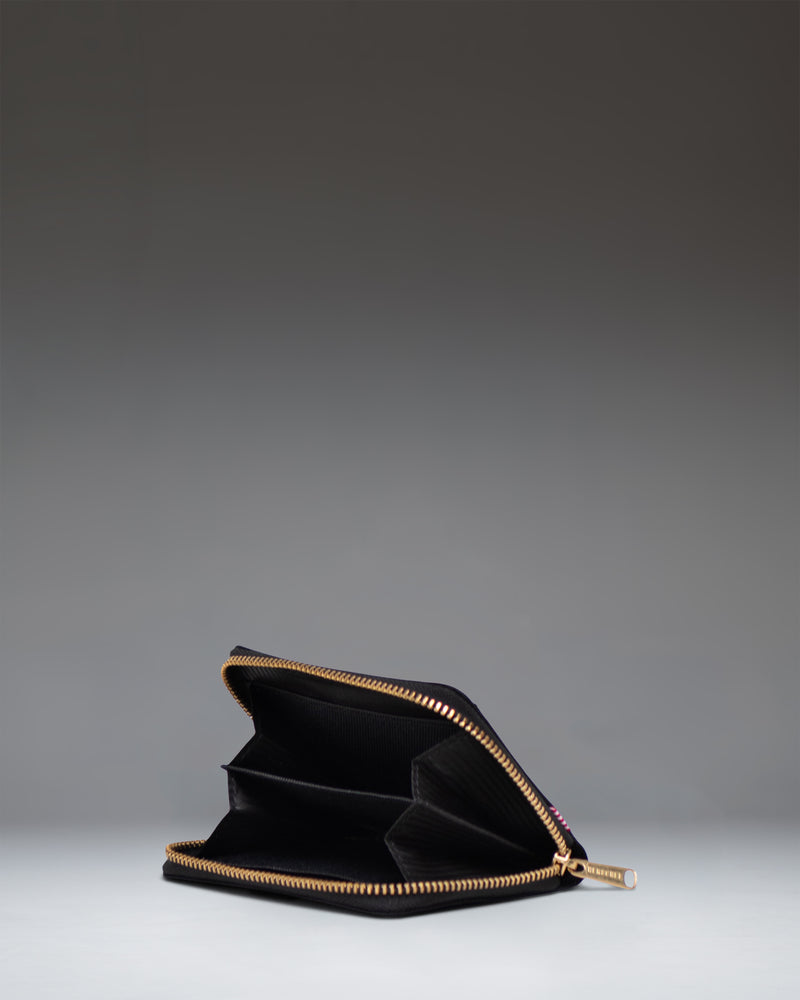 Black Herschel Supply Co Tyler Wallet shown from an overhead perspective, displaying its interior slots and zippered compartment.