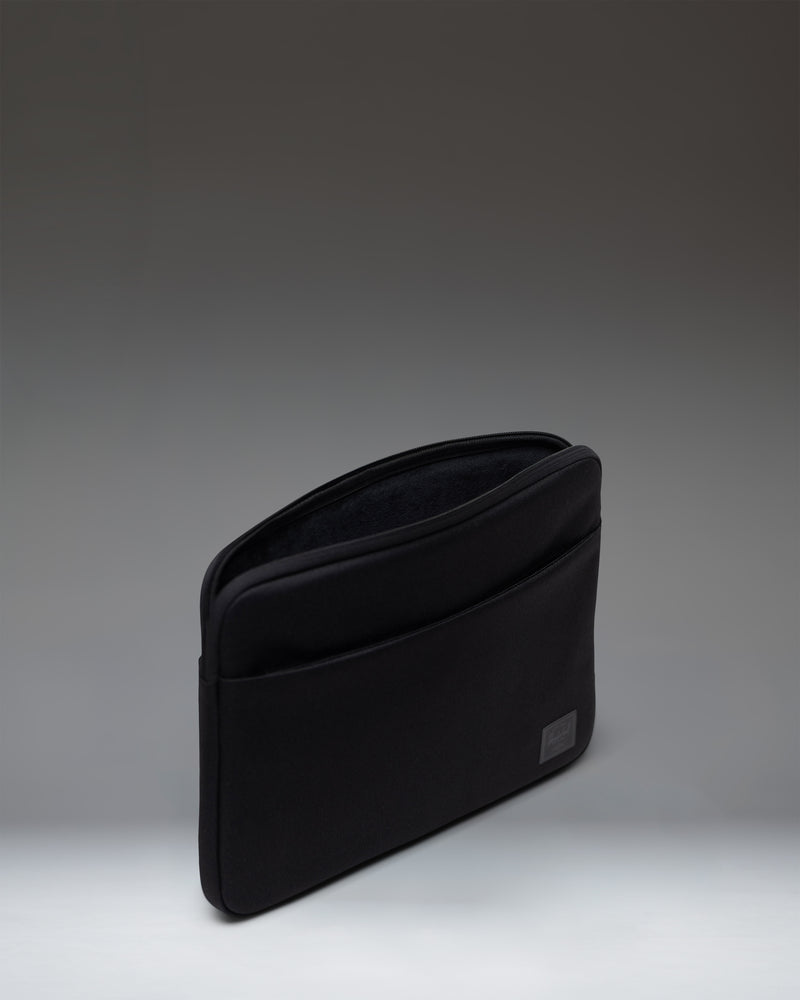 Herschel Supply Co Denman 14 Inch Sleeve Tech in black, showing the back view of the sleek laptop sleeve with minimal branding.