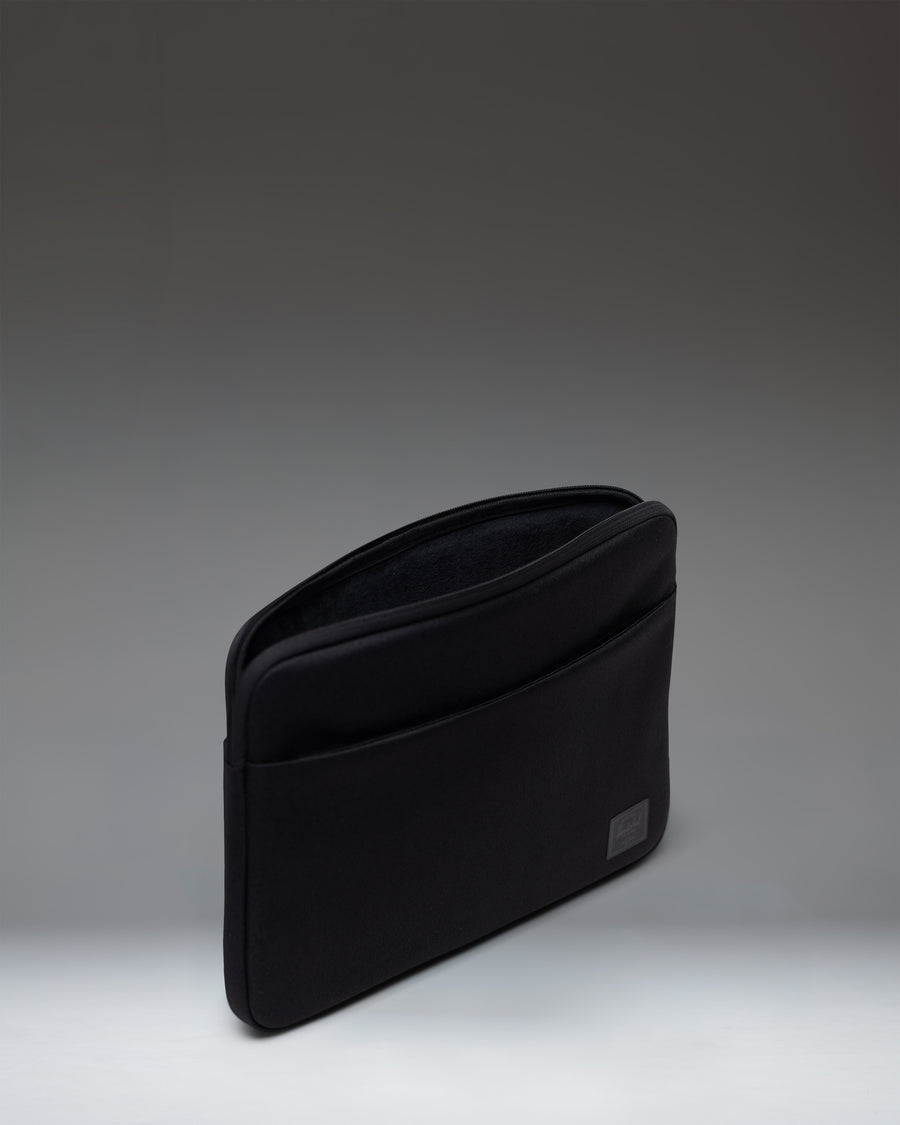 Herschel Supply Co Denman 14 Inch Sleeve Tech in black, showing the back view of the sleek laptop sleeve with minimal branding.