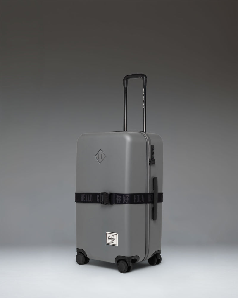 Herschel Supply Co. Black Luggage Belt laid out flat, featuring a durable adjustable strap and a prominent black buckle with subtle branding.