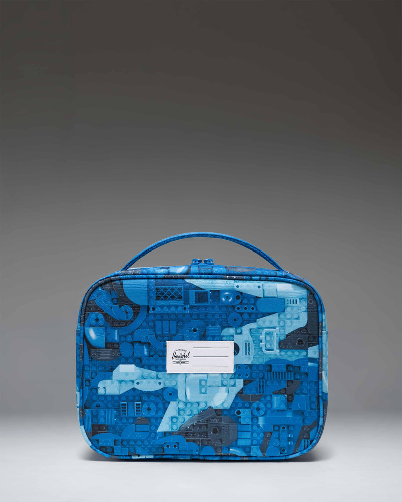 Herschel Supply Co. LEGO Pop Quiz Lunch Box in Abstract Bricks Blue, featuring a colorful LEGO brick pattern and zippered front pocket.