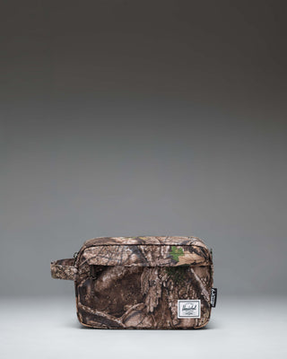 Herschel Supply Co. Realtree Chapter Travel Kit in Realtree APX Camo pattern, featuring a side handle and front zippered pocket.