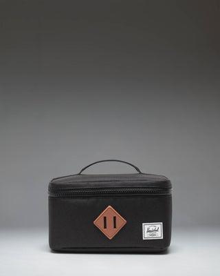 Herschel Heritage Lunch Box Little Herschel in black, featuring a classic rectangular design with a top handle and front storage sleeve.