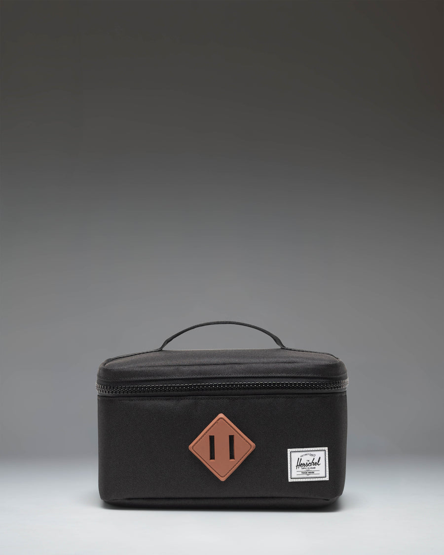 Herschel Heritage Lunch Box Little Herschel in black, featuring a classic rectangular design with a top handle and front storage sleeve.