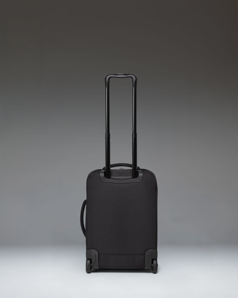 Black Herschel Heritage Softshell Large CarryOn Luggage shown from the side with wheels and telescopic handle extended.