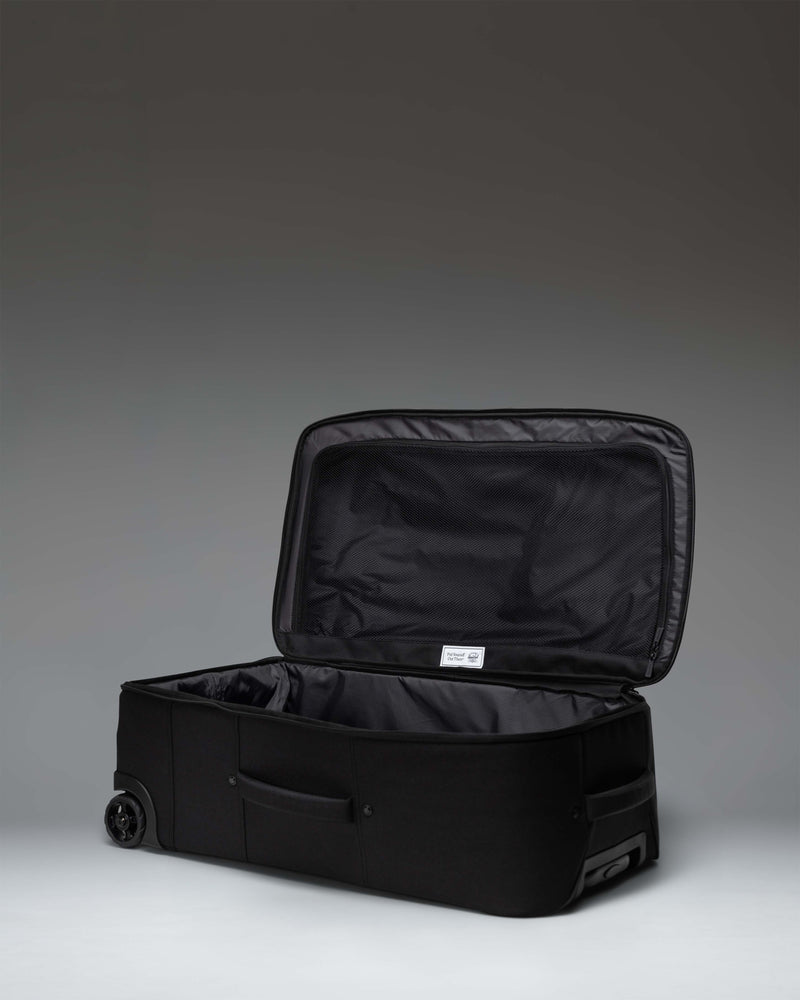 Herschel Heritage Softshell Medium Luggage in black, featuring a durable exterior, wheels, and a telescopic handle.