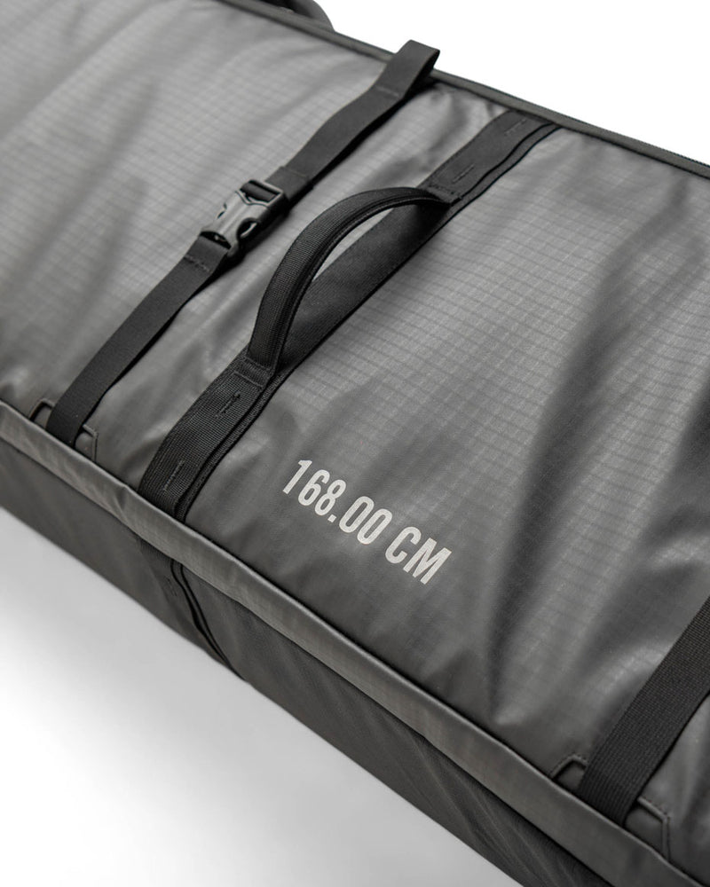 Black Herschel Supply Co. Snow Roller Bag (188cm) shown fully packed with snowboard gear, jackets, and winter sports equipment.