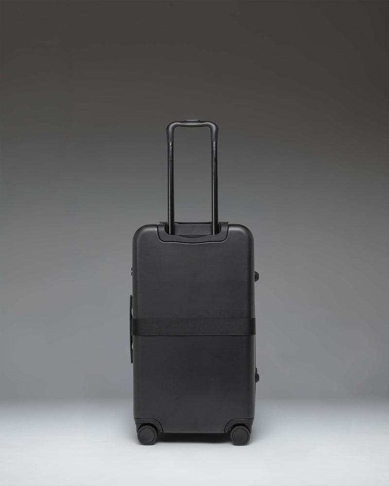Herschel Heritage Hardshell Medium Luggage Exp in Black, featuring an oversized front pocket and durable hard shell.