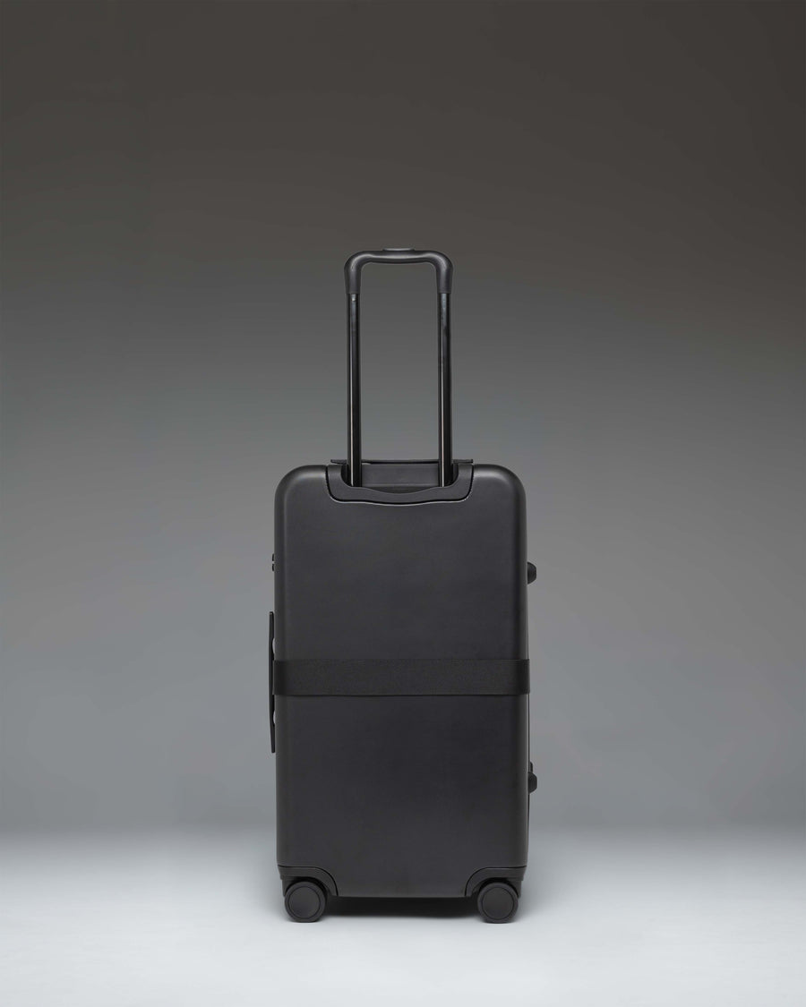 Herschel Heritage Hardshell Medium Luggage Exp in Black, featuring an oversized front pocket and durable hard shell.