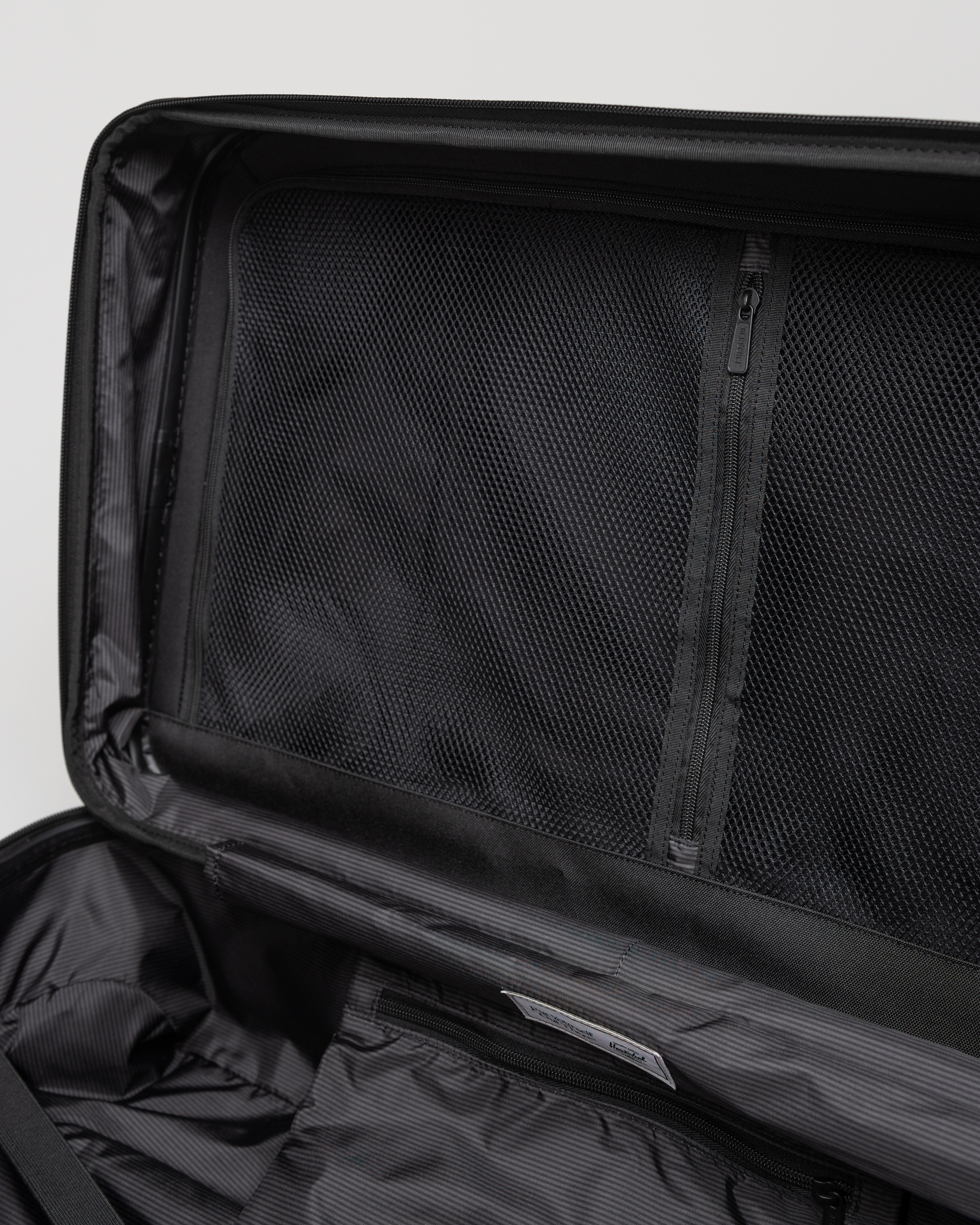 Herschel Heritage Hardshell Medium Luggage Expandable featuring 360-degree wheels, retractable trolley handle, and internal storage sleeves.