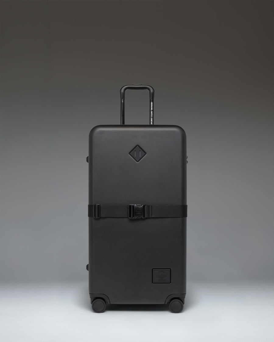 Herschel Heritage Hardshell Large Luggage Exp in Black, showing the front view of the durable rolling suitcase.