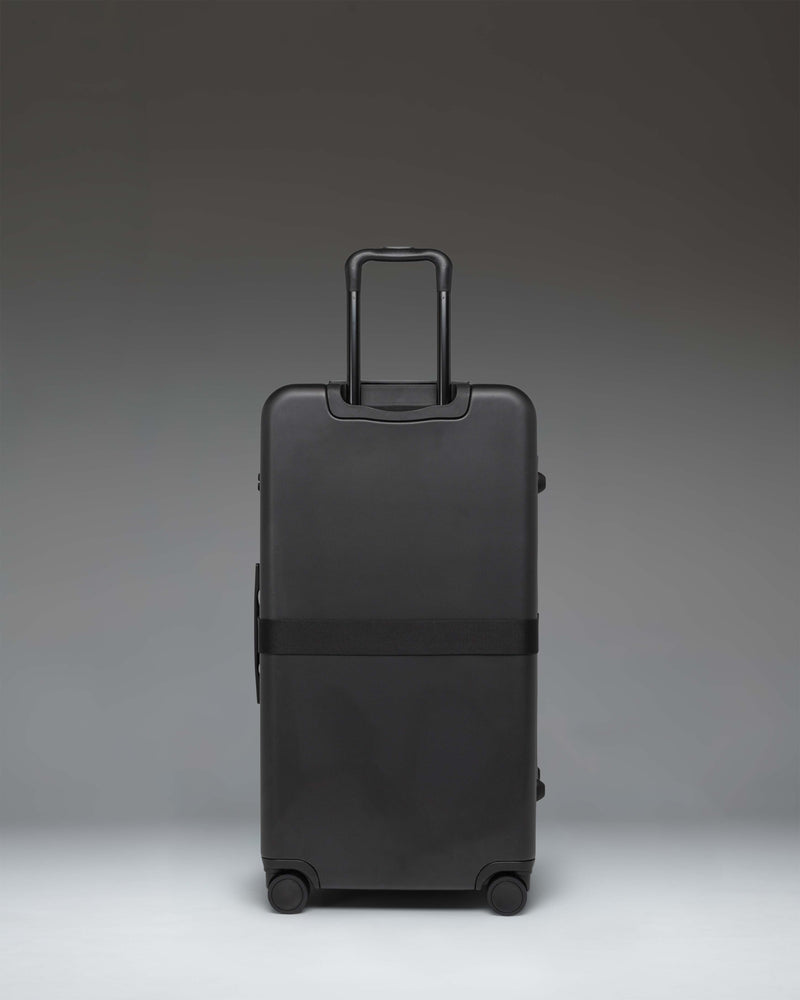Black Herschel Heritage Hardshell Large Luggage Exp rolling suitcase shown from a side view.