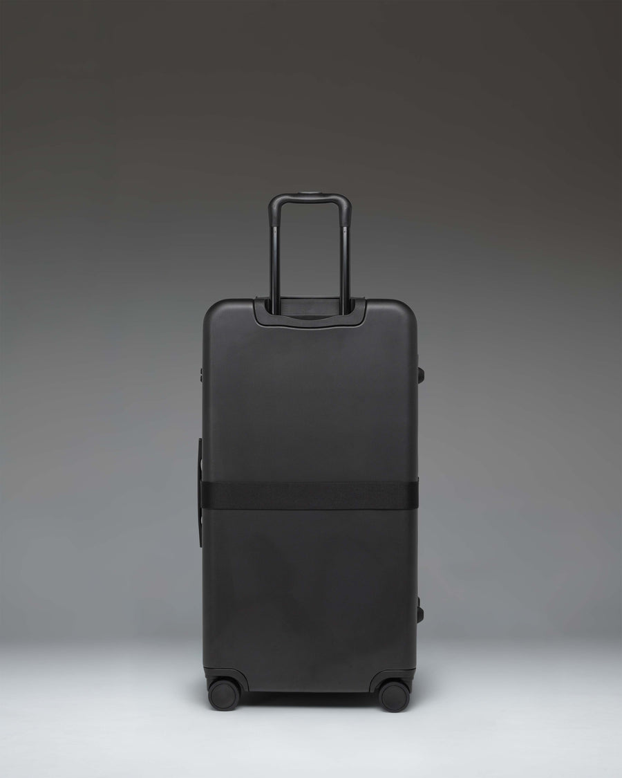 Black Herschel Heritage Hardshell Large Luggage Exp rolling suitcase shown from a side view.