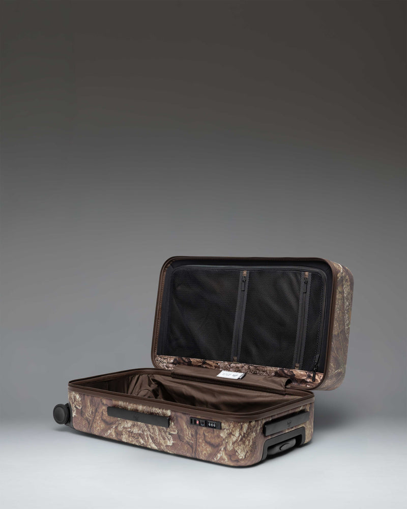 Herschel Heritage Medium Luggage in Realtree APX Camo pattern, showing the front view of the rolling suitcase with a black handle.
