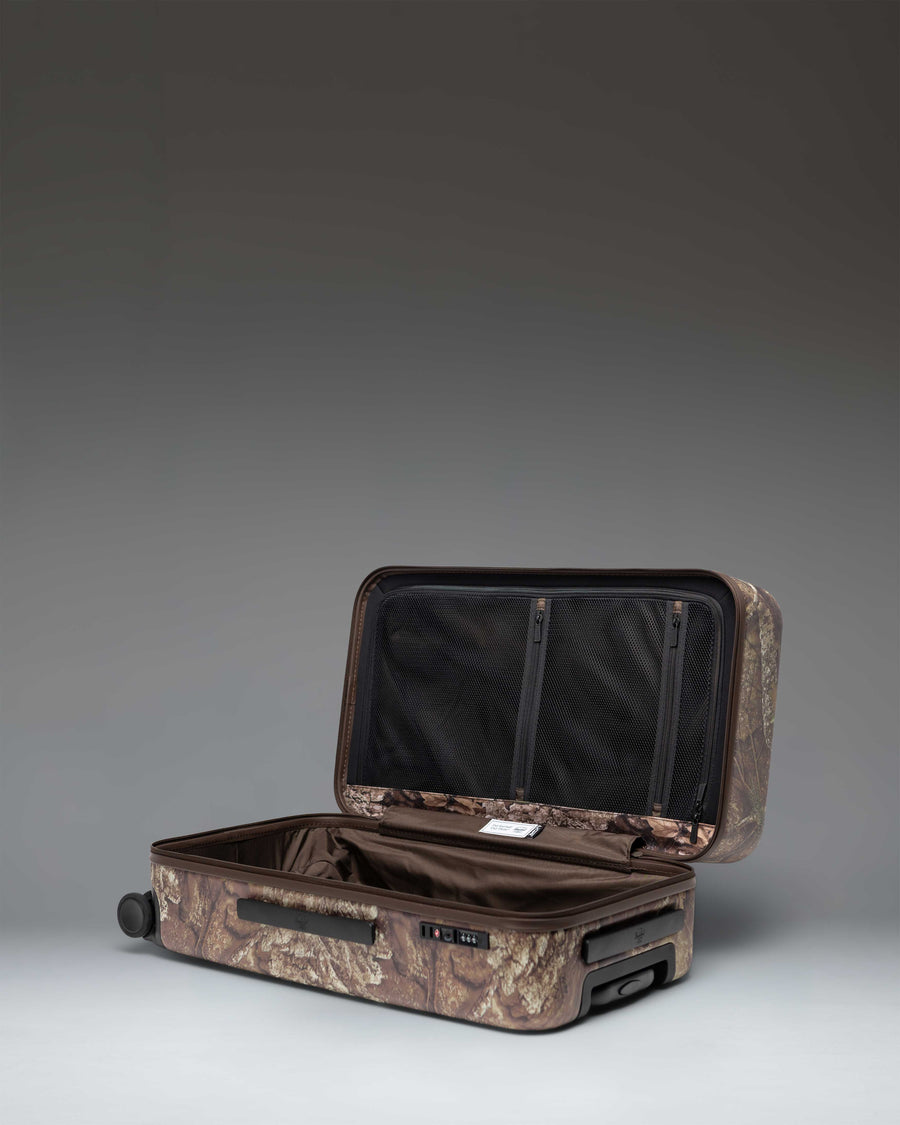 Herschel Heritage Medium Luggage in Realtree APX Camo pattern, showing the front view of the rolling suitcase with a black handle.