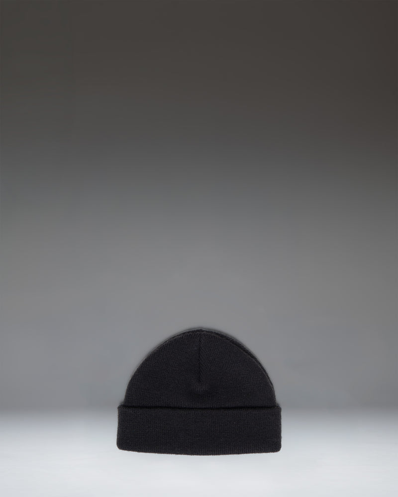 Herschel Supply Co. Elmer Baby Beanie for ages 0 to 6 months in black, featuring a classic ribbed knit design with a folded cuff and woven logo label.