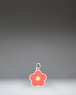 Herschel Daisy Bag Charm in Pink Daisy, featuring a stylized pink daisy flower design with a central yellow disc and attached metal hardware.