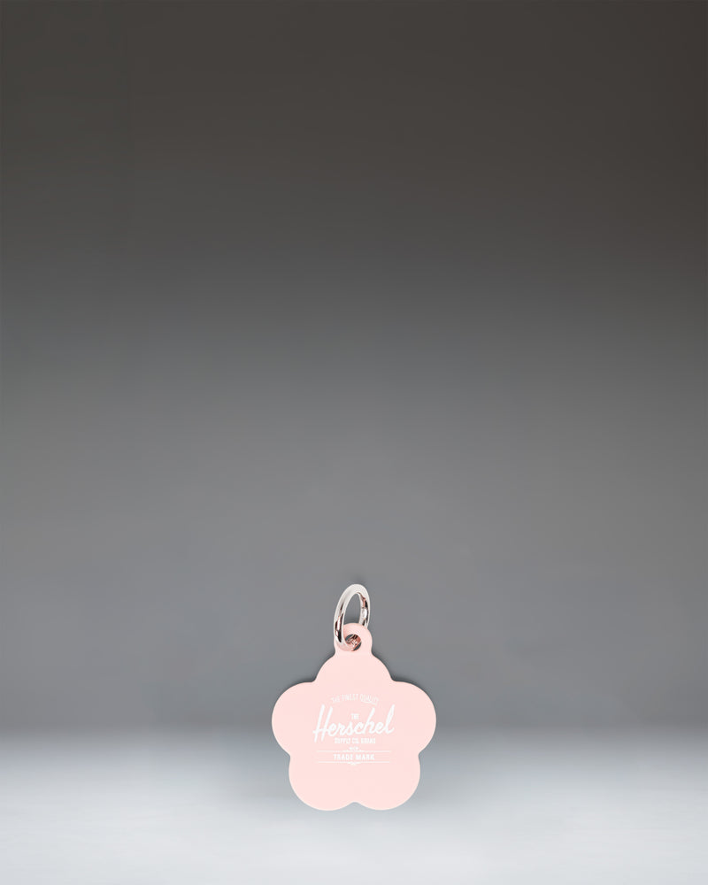 Herschel Supply Co. Pink Daisy Bag Charm, featuring a soft pink daisy flower design with a gold-tone keyring clip.