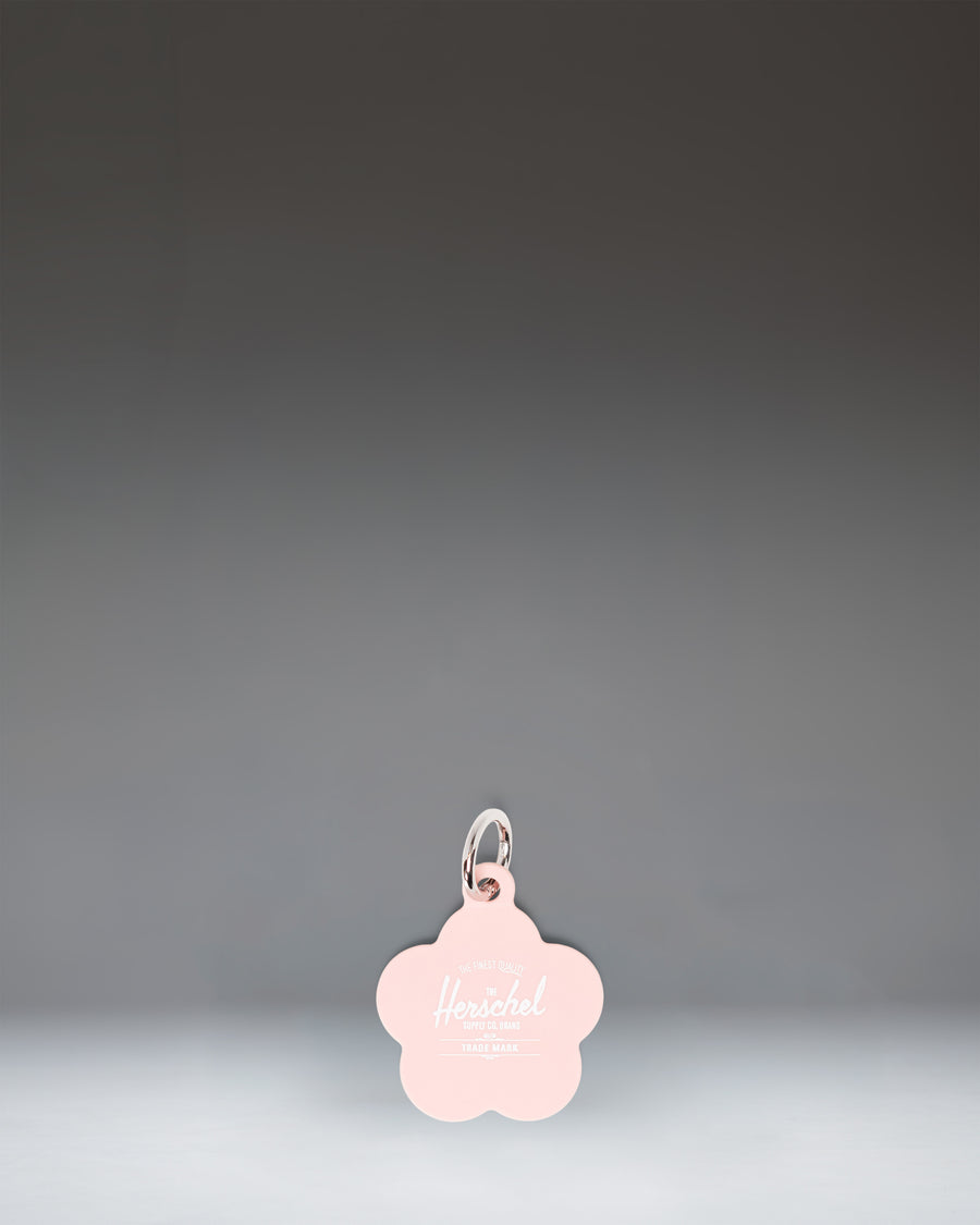 Herschel Supply Co. Pink Daisy Bag Charm, featuring a soft pink daisy flower design with a gold-tone keyring clip.