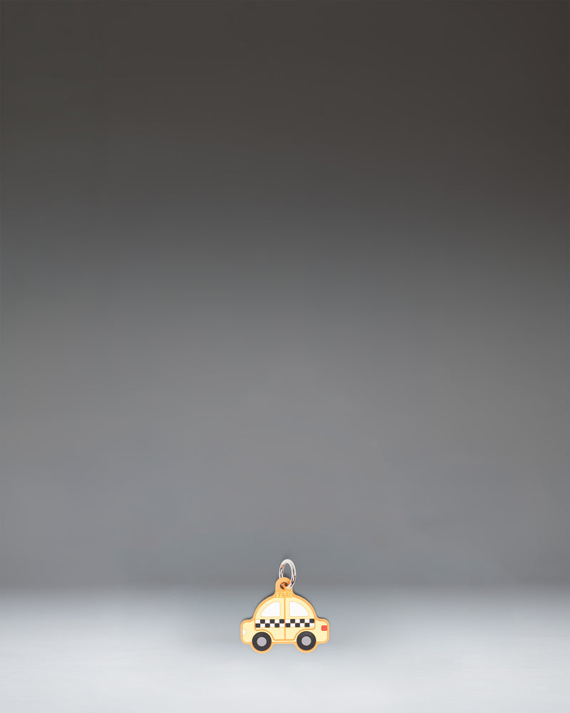 Herschel Taxi Bag Charm in Taxi, a yellow checker-cab-inspired miniature bag accessory with black and white checkered details.
