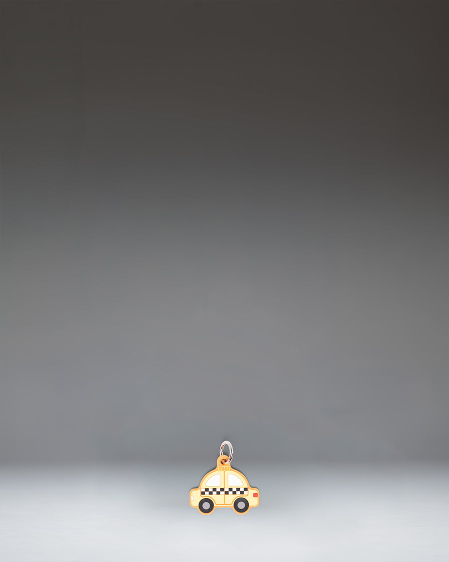 Herschel Taxi Bag Charm in Taxi, a yellow checker-cab-inspired miniature bag accessory with black and white checkered details.