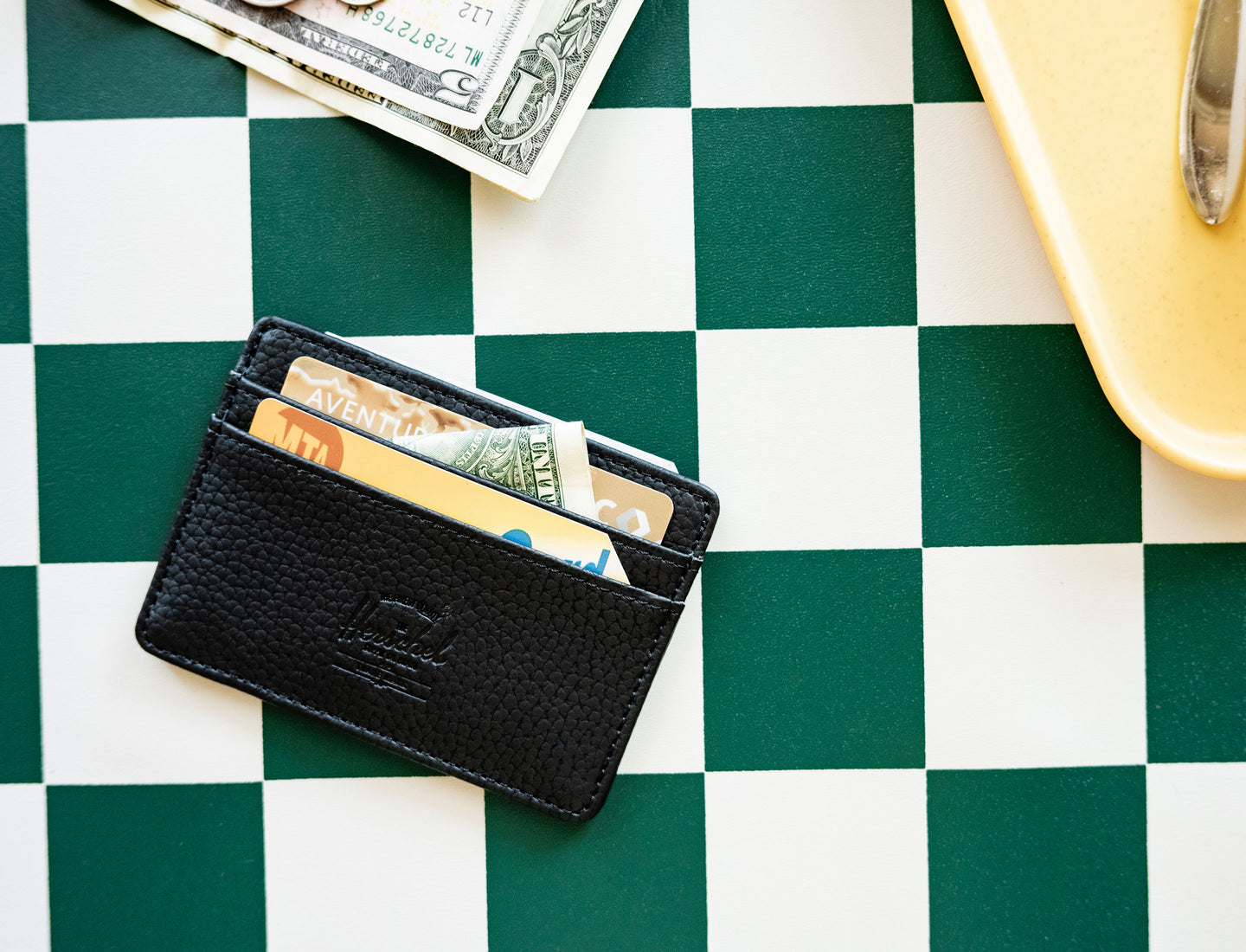 Herschel Supply Co. Charlie Cardholder in black vegan leather, showing the front slots and classic woven label.