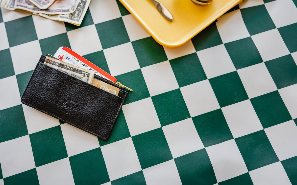 Herschel Supply Co. Oscar Large Cardholder in black vegan leather, shown from a front angle to highlight its compact design and card slots.