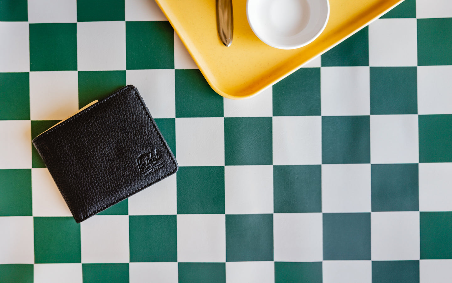 Herschel Supply Co. Roy Wallet in textured black vegan leather, featuring a classic bi-fold design with multiple internal card slots.
