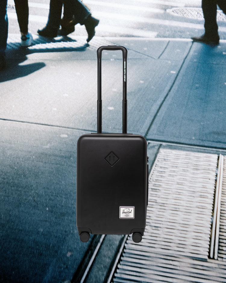Herschel Heritage Hardshell Large CarryOn Luggage in Black, a durable hard-shell rolling suitcase.