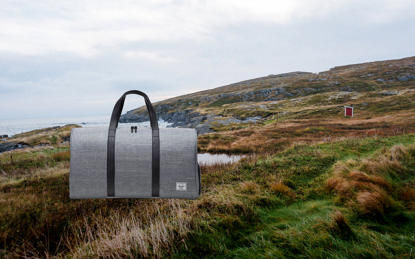 Herschel Novel Duffle bag in Raven Crosshatch grey with black straps, displayed on a clean background.