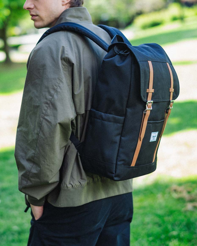 Herschel Supply Co. Herschel Retreat Backpack in black, showcasing a clean front view with dual rubber straps and a classic woven label.